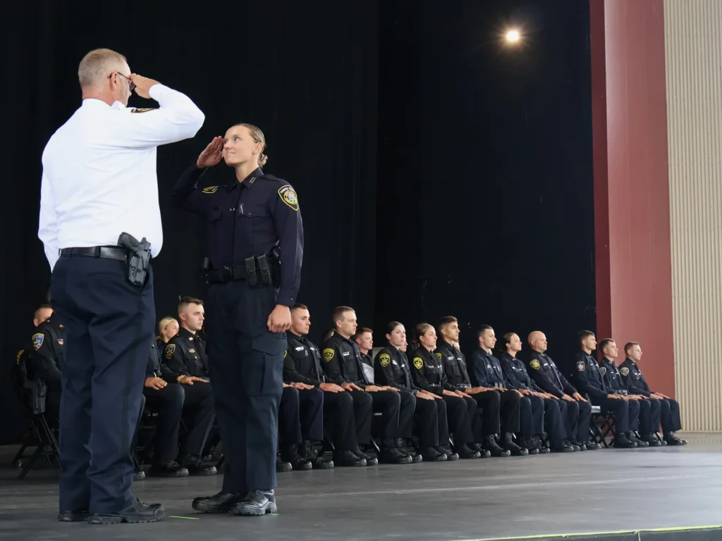 Shaina Sexton, a new FLCC Campus Police officer, salutes Police Chief Matthew McGrath during the Finger Lakes Law Enforcement Academy graduation in August 2025.